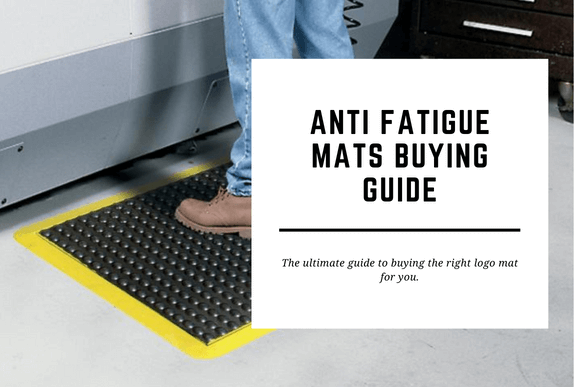 A man stands on an anti fatigue mat in front of a workstation. The blog header reads Anti Fatigue Mats Buying Guide.