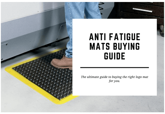 A man stands on an anti fatigue mat in front of a workstation. The blog header reads Anti Fatigue Mats Buying Guide.
