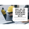 A yellow hard hat and a laptop are placed on a desk where someone is working. The blog header reads What are The Building Code Requirements for Entrance Mats?