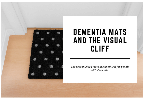 A dementia black mat sits in front of a closed white door. The blog header reads Dementia Mats and the Visual Cliff.