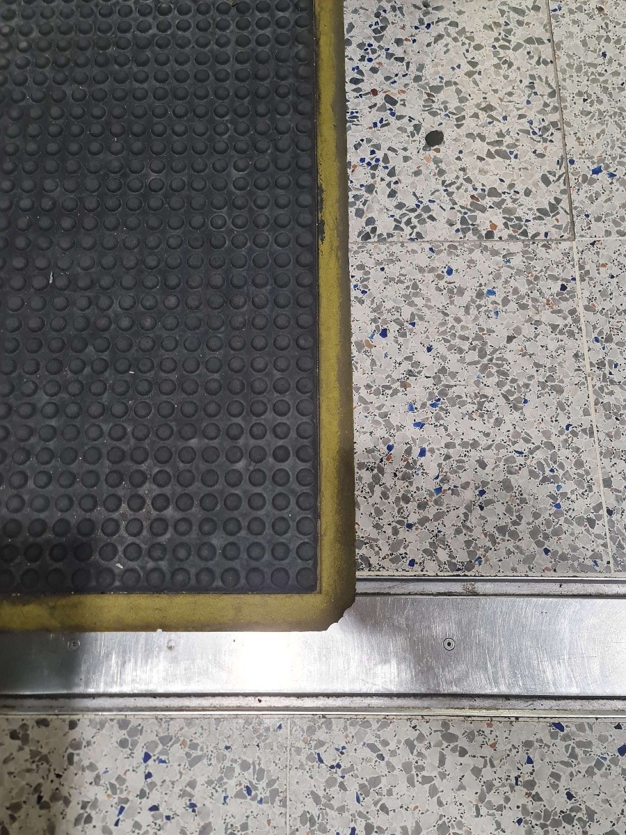 The dirty yellow borders of an anti fatigue mat.