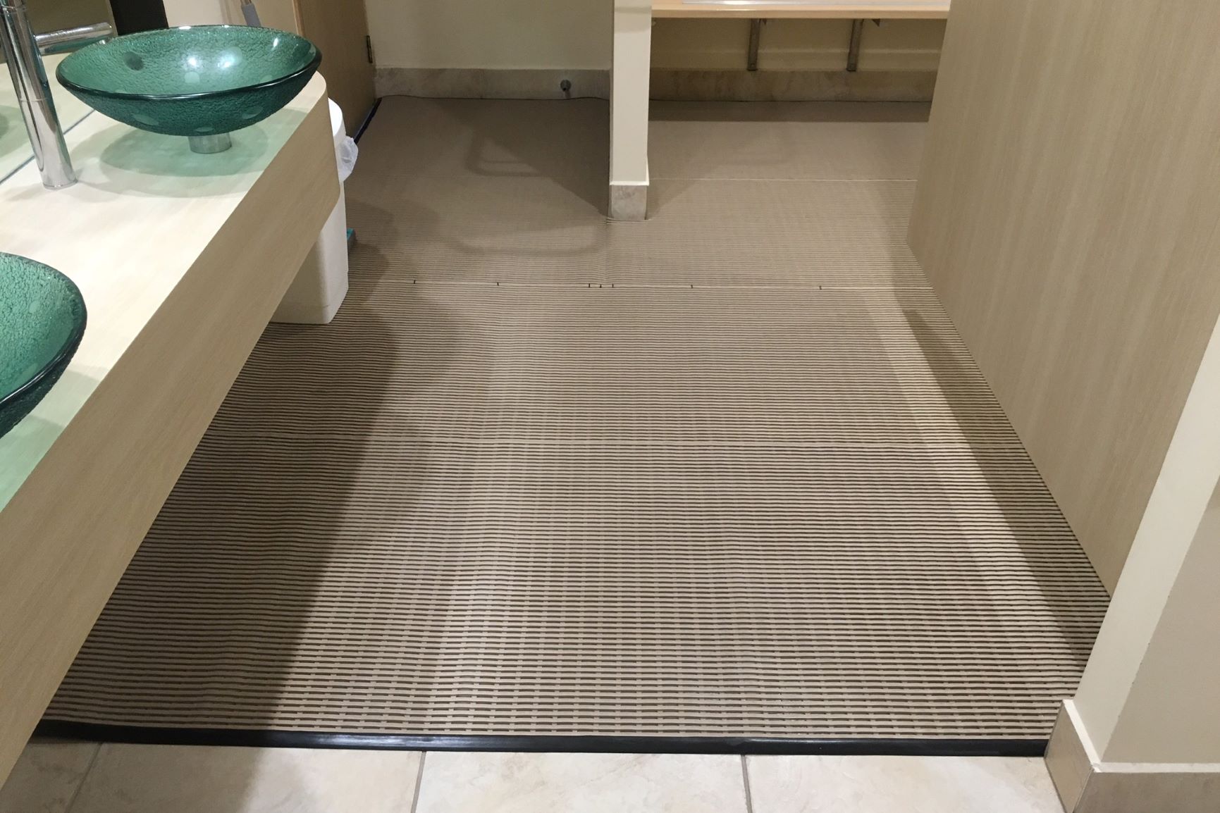 Rubber non slip matting lines the floor of a swimming pool changing room.