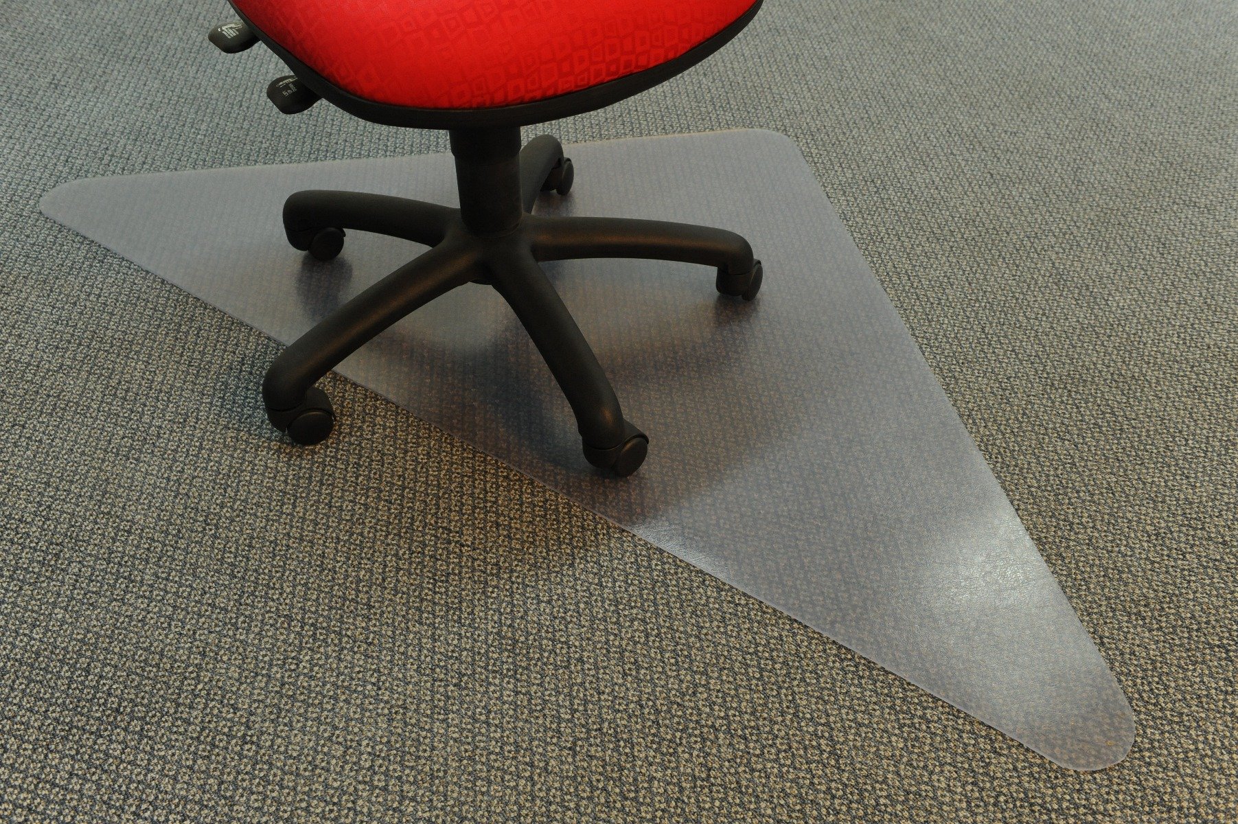A red office chair with castors sits on top of a transparent chair mat for carpet.